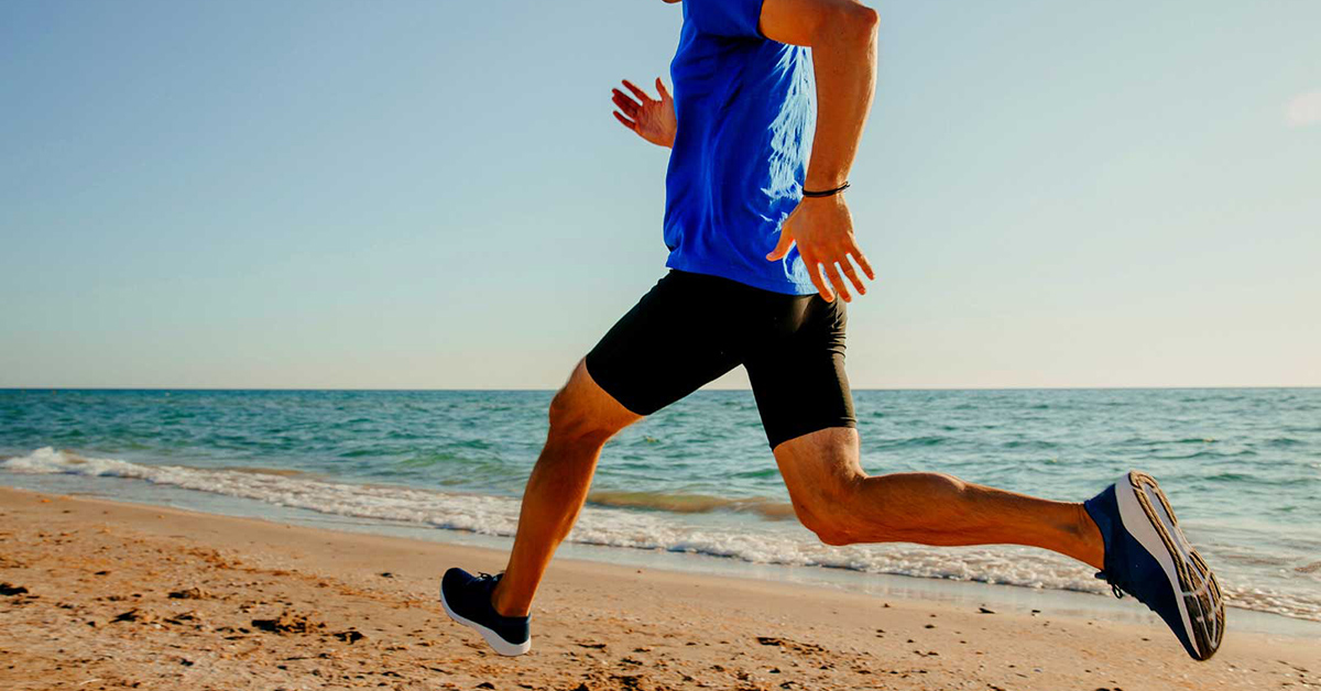 staminade-sports-drink-best-time-to-run-in-summer man running along the beach